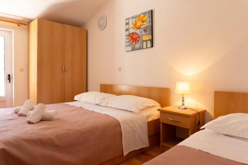 a hotel room with two beds and a lamp at Apartmani Tona in Gradac