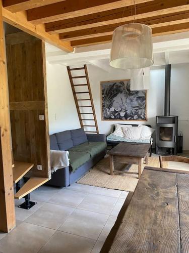 un salon avec un canapé bleu et une échelle dans l'établissement L’escapade, coeur de la nature, à Saint-Hippolyte-du-Fort