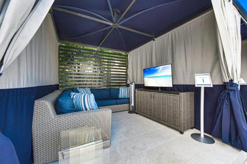 a room with a couch and a tv in a tent at Anna Maria Beach Resort in Holmes Beach