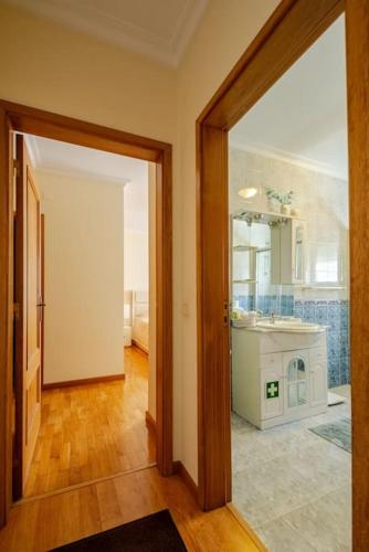 a room with a kitchen with a sink and a mirror at Remédios Apartment in Lamego
