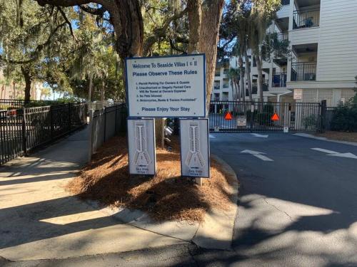 a sign on the side of a street next to a tree at Beachin It!-Oceanview Updated 2024, King Bed Bikes in Hilton Head Island