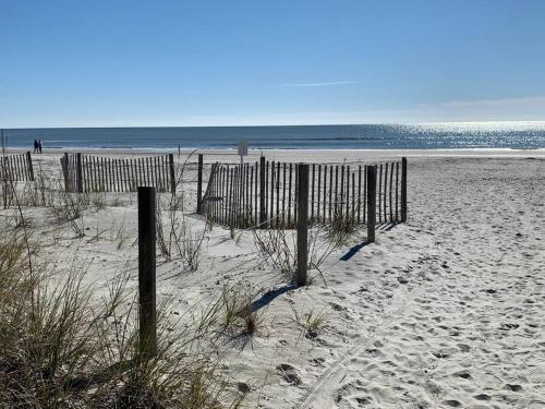 a beach with a fence in the sand at Beachin It!-Oceanview Updated 2024, King Bed Bikes in Hilton Head Island