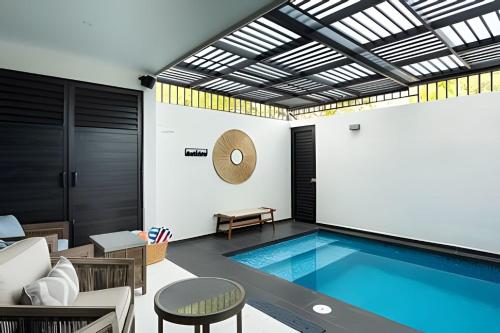 une piscine dans un salon avec une table et des chaises dans l'établissement New! Fluvial Casa con Alberca, à Bucerías