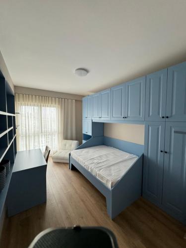 a bedroom with blue cabinets and a bed and a couch at The Boulevard Bliss in Tirana