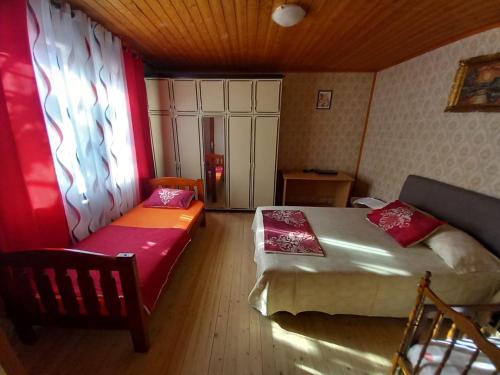 een slaapkamer met 2 bedden, een bank en een raam bij Etno House Mira in Virpazar