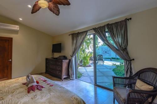 サン・ホセ・デル・カボにあるChris Casa del Sol San José del Cabo, 5 Bedroom Private Pool and Spaのベッドルーム1室(ベッド1台付)、スライド式ガラスドアが備わります。
