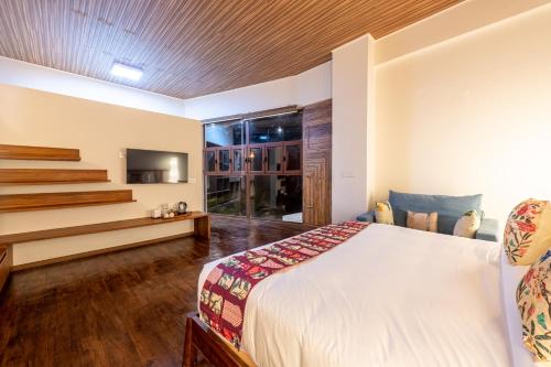 a hotel room with a bed and a tv at Asta in Ooty