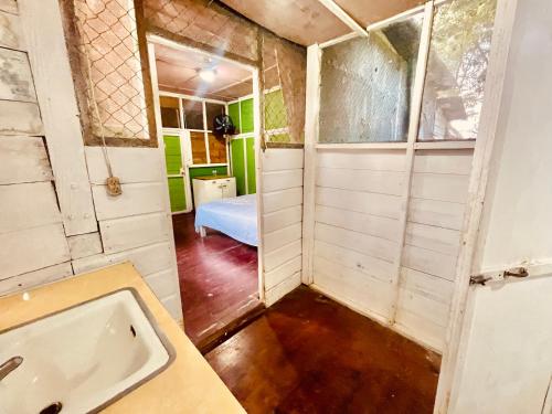 - une salle de bains avec baignoire et un lit dans une chambre dans l'établissement HOTEL BACKPACKERS RIO DULCE, à Rio Dulce