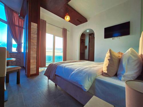 - une chambre avec un lit et une vue sur l'océan dans l'établissement Pamja e Qyteteve, à Krujë