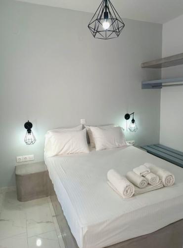 a bedroom with a white bed with towels on it at Lava Guesthouse Prive in Karterados