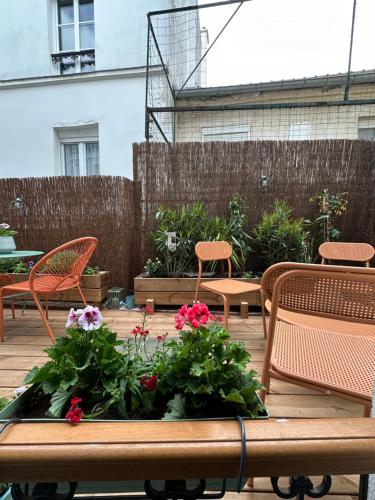a wooden table with flowers and chairs on a patio at RESIDENCE A LA BUTTE AUX CAILLES in Paris