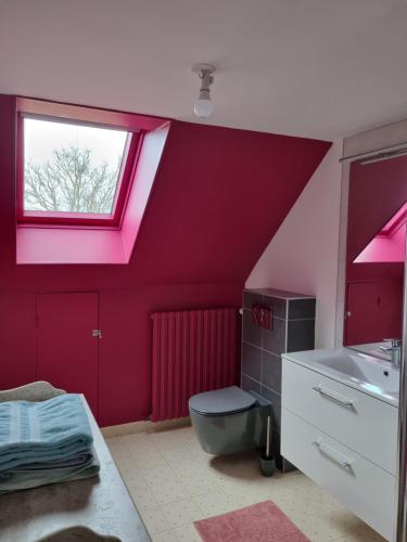 een badkamer met een rode muur met een raam en een wastafel bij Vaucelles city in Vaucelles