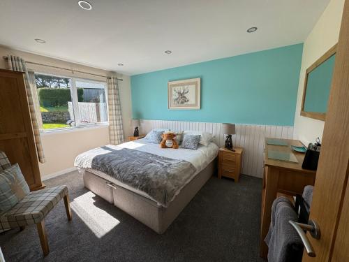 a bedroom with a bed with a teddy bear on it at Drumhead Cottage Finzean, Banchory Aberdeenshire Self Catering with Hot Tub in Finzean