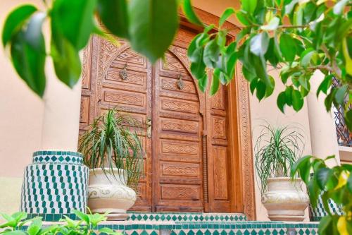 Villa in Central Marrakesh في مراكش: باب خشبي أمامه ثلاث خزاف