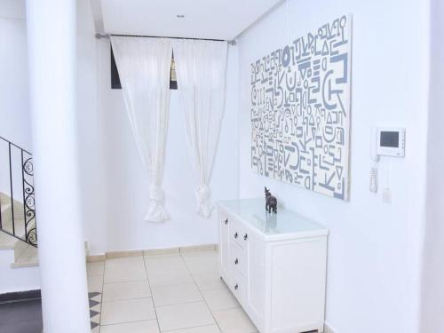 Villa in Central Marrakesh في مراكش: غرفة بيضاء مع خزانة بيضاء ونافذة
