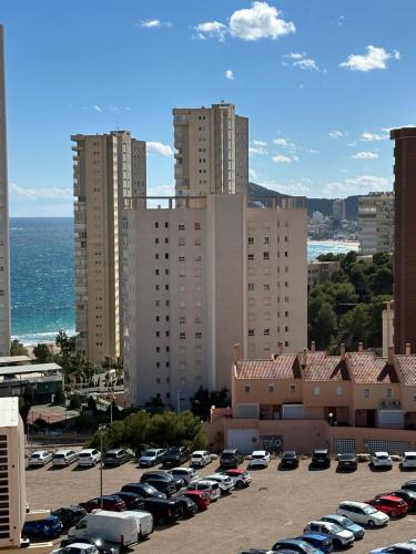 un estacionamiento con autos estacionados frente a edificios altos en Apartamento Suzanna, en Benidorm