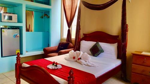 a bedroom with a bed with two flowers on it at See Belize TRANQUIL Sea View Studio with Balcony, Infinity Pool & Overwater Deck in Belize City