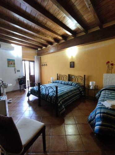 a bedroom with two beds and a couch at Affittacamere La Cartiera in Palazzo Adriano
