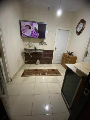 a bathroom with a toilet and a tv on the wall at Home north cost in Sīdī Sālim