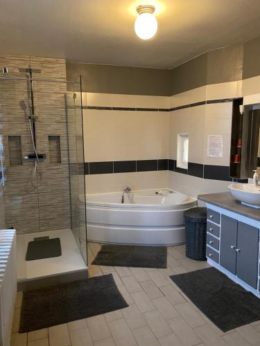 a bathroom with a tub and a shower and a sink at maison de maitre in Fleury-sur-Andelle
