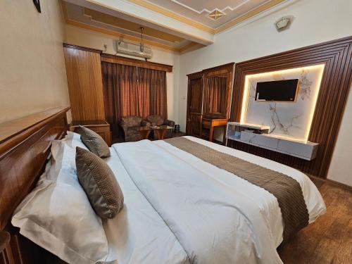 a bedroom with a large bed and a television at HOTEL CITY HEART in Chamba