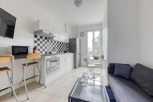 uma sala de estar com um sofá e uma cozinha em Cosy bleu proche arena JO (Bercy), RER C, métro 7 em Ivry-sur-Seine