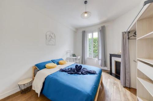 une chambre avec un lit bleu et une cheminée dans l'établissement Cosy bleu proche arena JO (Bercy), RER C, métro 7, à Ivry-sur-Seine