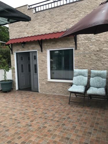 two chairs sitting on a brick patio next to a building at Villa Milka in Utjeha