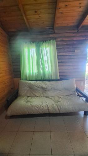 a bed sitting in a room with a window at Los Tronquitos in Santa Rosa de Calamuchita