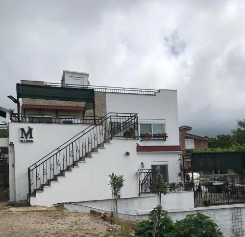 a white building with a staircase on the side of it at Villa Milka in Utjeha