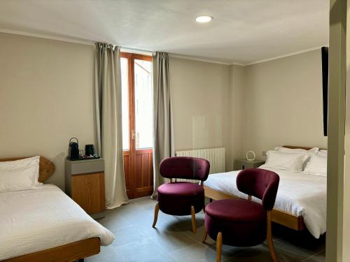 una camera d'albergo con due letti e due sedie di Camere di Bianca a Foligno