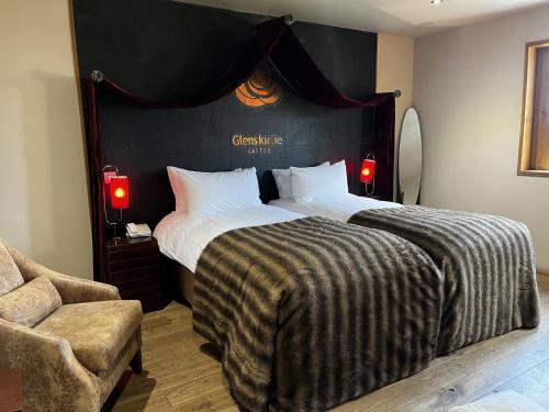 a bedroom with a large bed with a black headboard at Glenskirlie Castle Hotel in Banknock