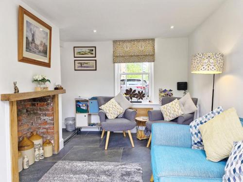 a living room with two blue couches and a fireplace at Four Priory Road, Chichester in Chichester