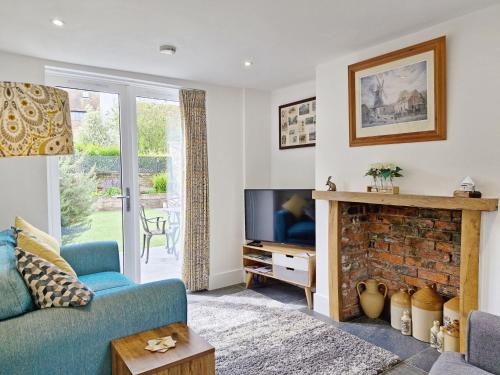 a living room with a blue couch and a fireplace at Four Priory Road, Chichester in Chichester