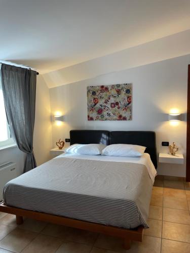1 dormitorio con 1 cama grande y una pintura en la pared en Bellavista en Fossacesia