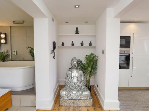 HollingtonにあるZanzibar Beach Houseの浴槽のある浴室に置かれた大きな銀の像