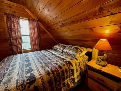 a bedroom with a bed in a log cabin at Mountain Cabin 2B Jacuzzi #10 in Helen