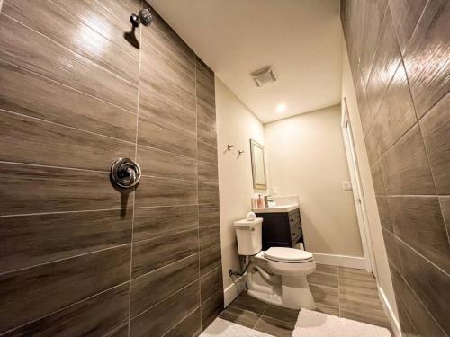 a bathroom with a toilet and a glass shower at Exclusive Lake Tiny House in Beautiful Japanese Garden in Homestead