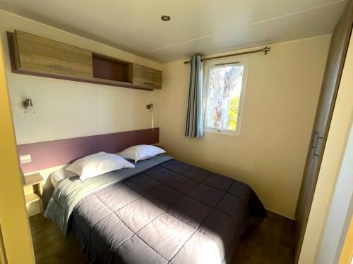 a bedroom with a bed in a room with a window at Camping Dolce Vita in Calvi