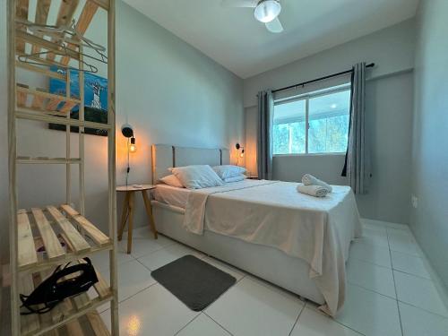 um quarto com uma cama e uma janela em Apto com VISTA ESPETACULAR a BEIRA MAR no Pecado - Wi Fi 200 mb - 2 Quartos - Garagem - TV Smart - Piscina - Sauna - Ar condicionado - Portaria 24h - Churrasqueira - Cozinha equipada em Macaé