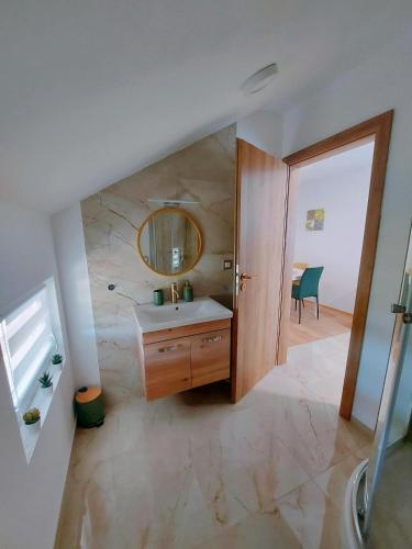 a bathroom with a sink and a mirror on a wall at Sobe Tamaris in Slapno