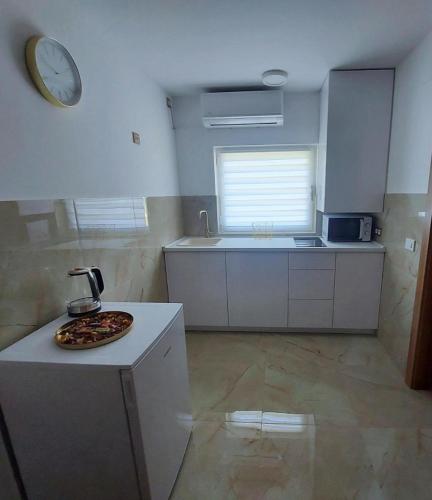 a kitchen with a pizza on top of a counter at Sobe Tamaris in Slapno