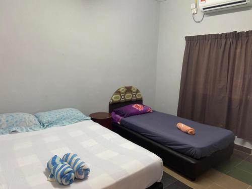 מיטה או מיטות בחדר ב-Padang Besar Guesthouse Firdaus