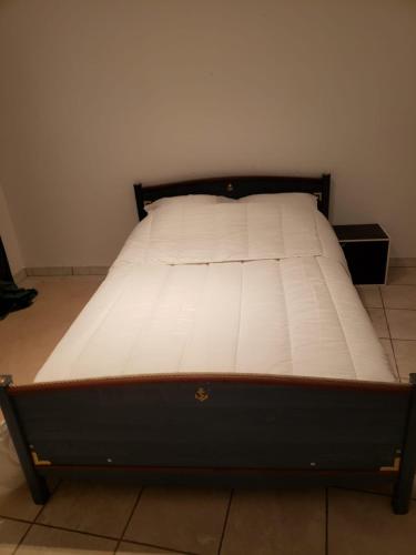 Ce lit se trouve dans un dortoir doté d'un matelas blanc. dans l'établissement Maison meublée avec garage, à Pamiers
