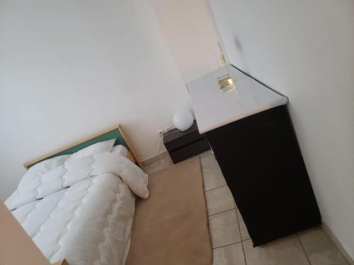 une chambre avec un lit blanc et une armoire noire dans l'établissement Maison meublée avec garage, à Pamiers