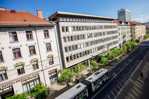 ein Zug auf einer Straße vor Gebäuden in der Unterkunft Central View Point Apartment in Ljubljana