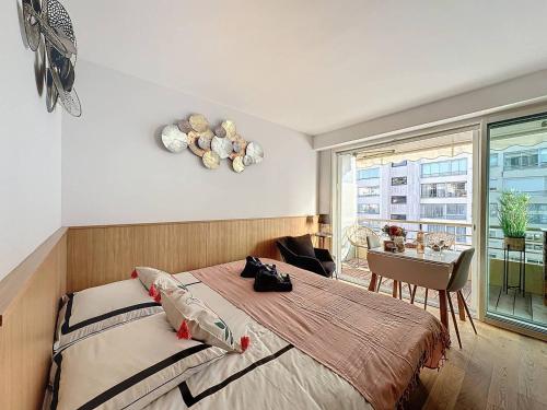 1 dormitorio con cama, mesa y ventana en GHH406 - Résidences du Grand hôtel Studio avec terrasse en Cannes