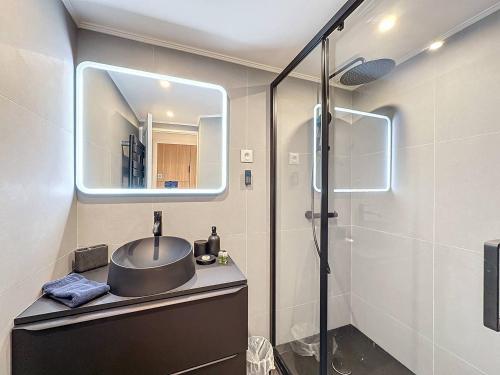 y baño con lavabo, espejo y ducha. en GHH406 - Résidences du Grand hôtel Studio avec terrasse en Cannes