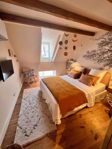 a bedroom with a large bed in a attic at Le Toit des Hospices : HyperCentre/Vue/Clim in Beaune