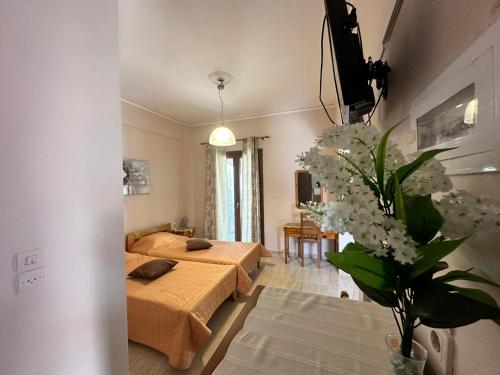 a bedroom with two beds and a vase of flowers at Nikos Holidays Apartment 1 in Petra